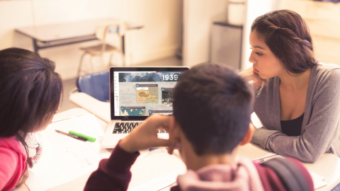 Student group viewing Holocaust timeline on computer